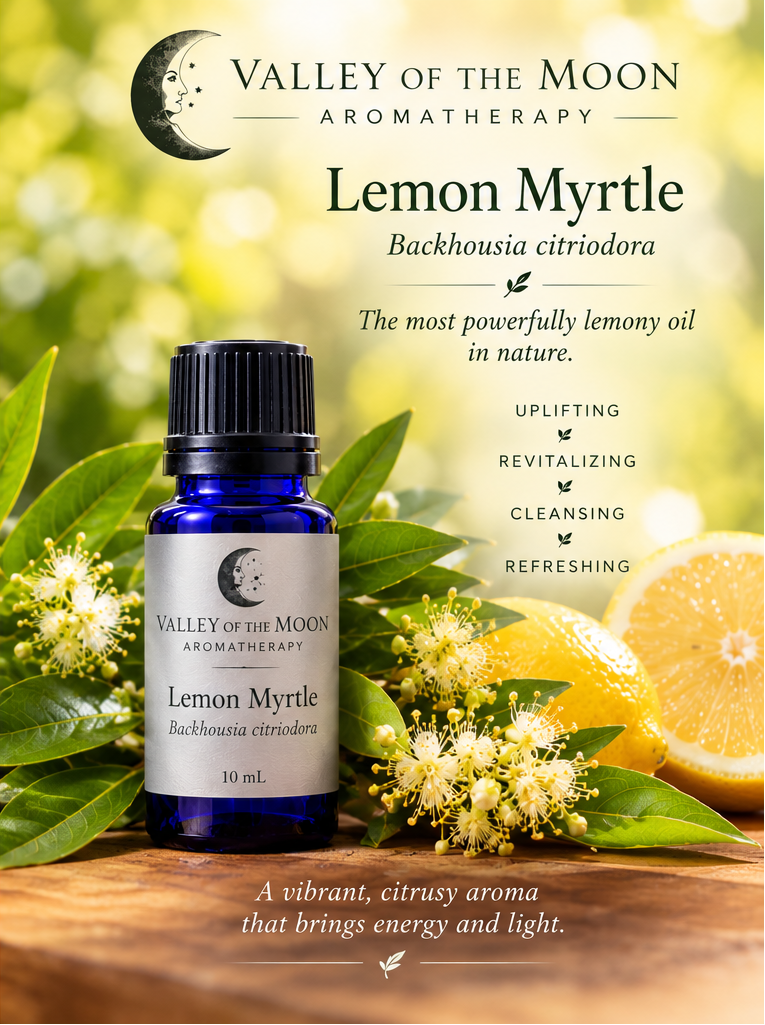 A 10 mL bottle of Valley of the Moon Aromatherapy Lemon Myrtle essential oil displayed on a wooden surface, surrounded by fresh green leaves, yellow blossoms, and sliced lemons against a soft, blurred yellow-green background with product text.