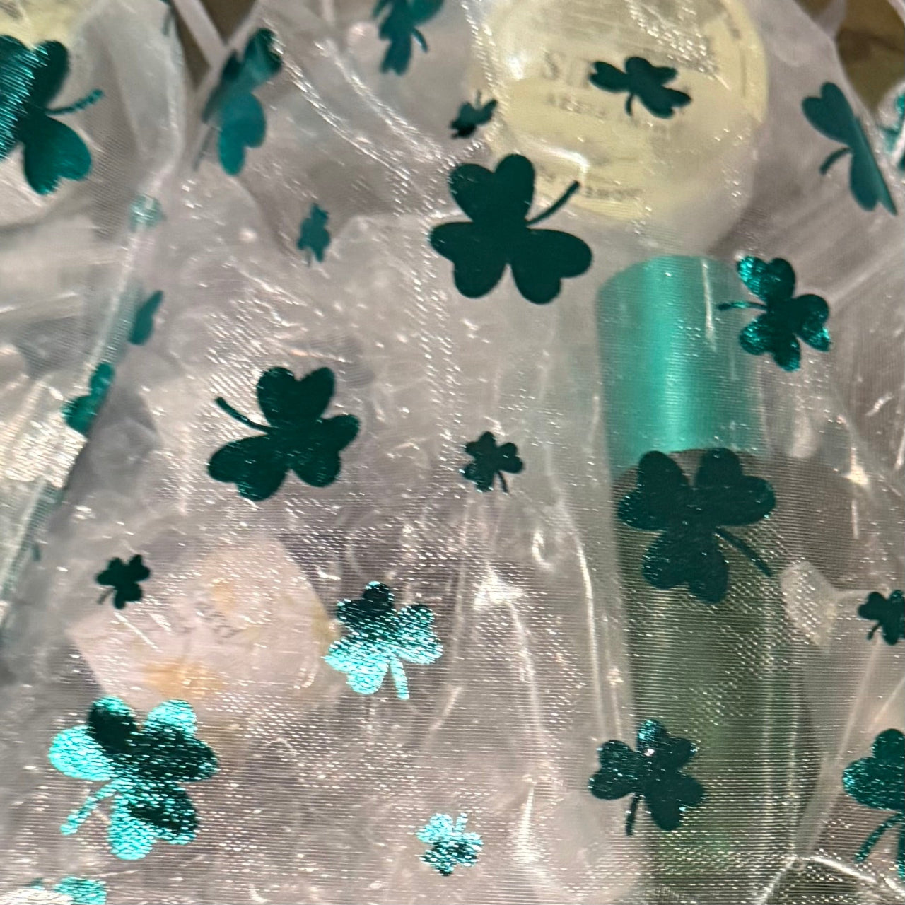 march-scent-club-Sheer fabric with green shamrock patterns on a white background